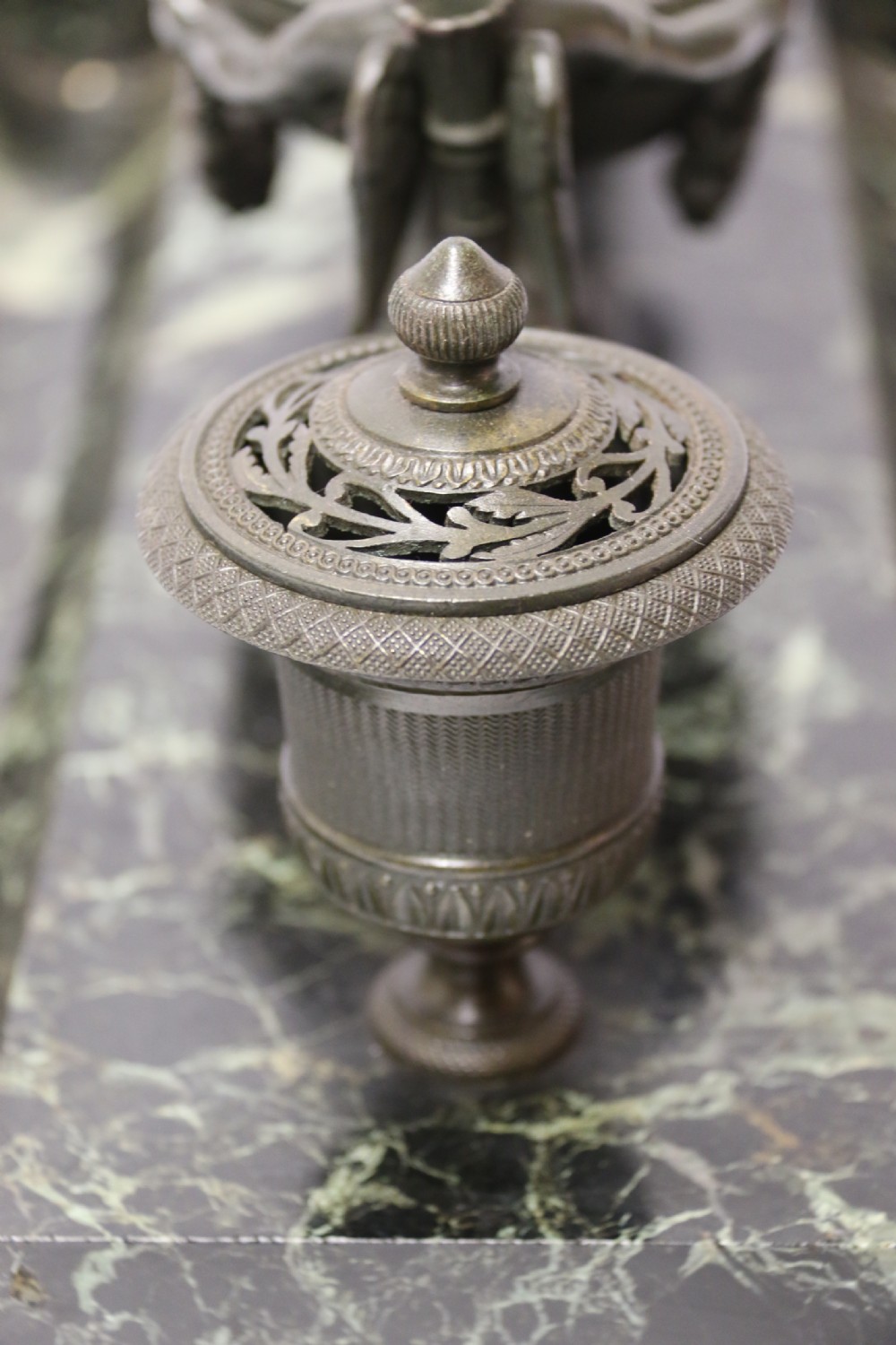An Empire period dark green marble inkstand featuring dark patinated bronze cherub figures, twin urn inkwells, and carved claw feet. View XI