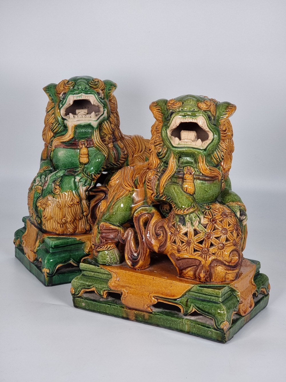 A large pair of Chinese pottery foo dogs with sancai glaze