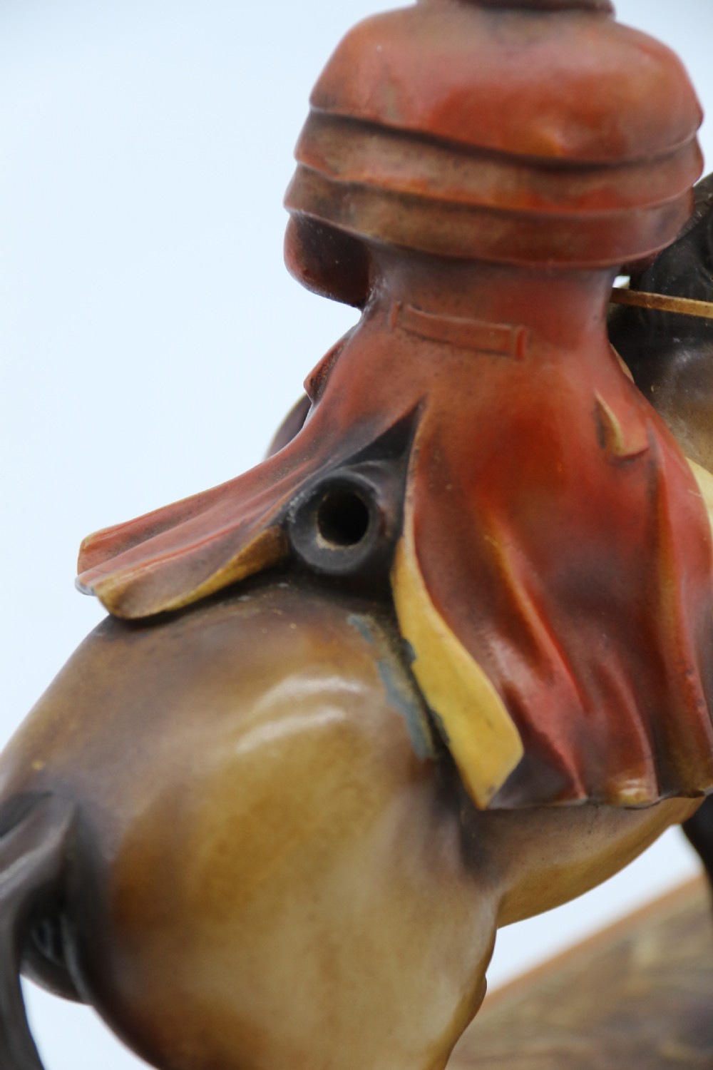 An Art Deco cold-painted metal figure of a masked highwayman on horseback mounted on a rectangular wooden plinth, featuring an integrated table lighter mechanism. View VI