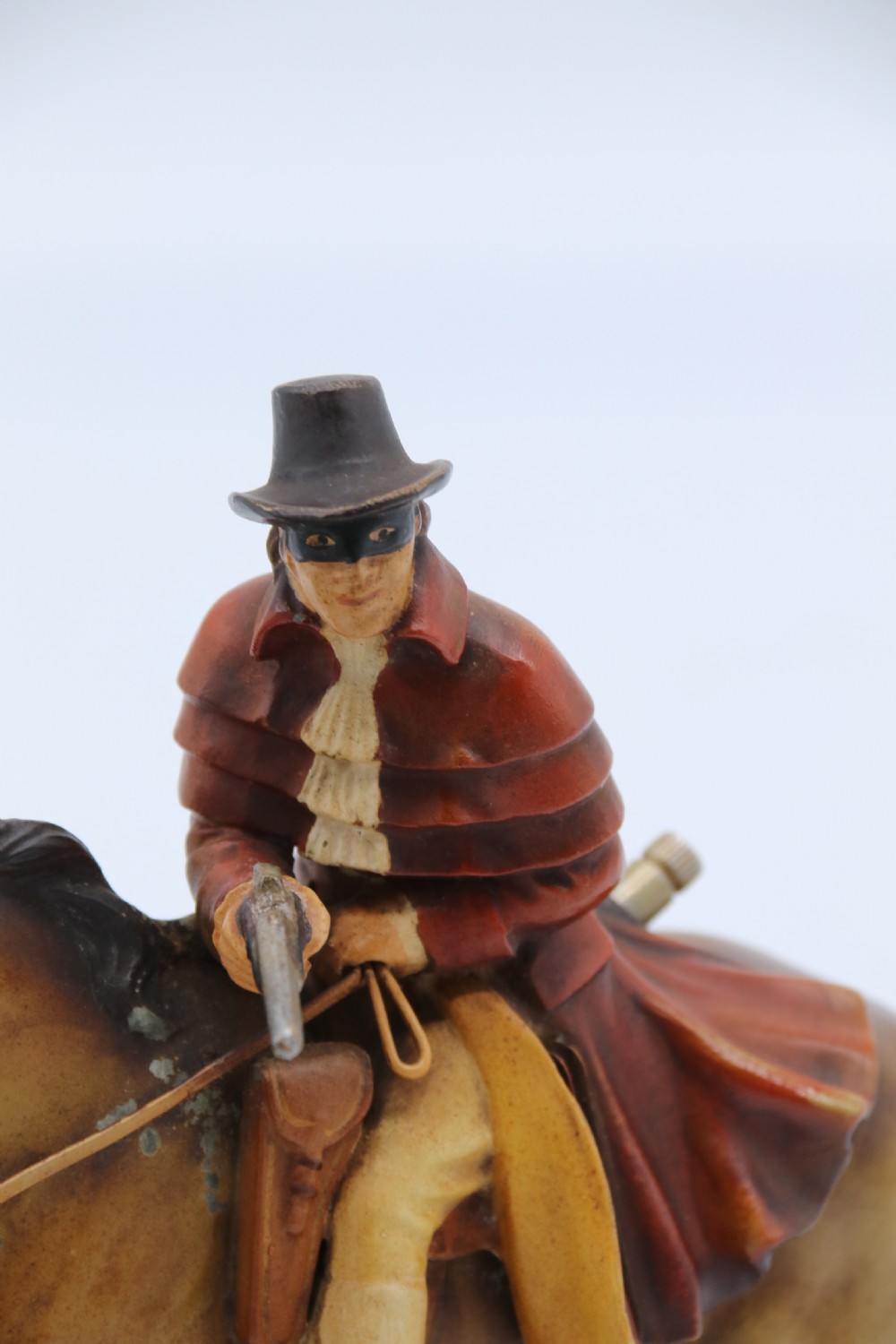 An Art Deco cold-painted metal figure of a masked highwayman on horseback mounted on a rectangular wooden plinth, featuring an integrated table lighter mechanism. View VIII