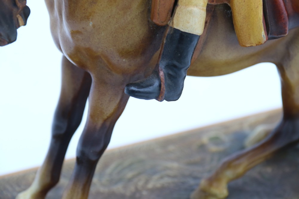 An Art Deco cold-painted metal figure of a masked highwayman on horseback mounted on a rectangular wooden plinth, featuring an integrated table lighter mechanism. View X