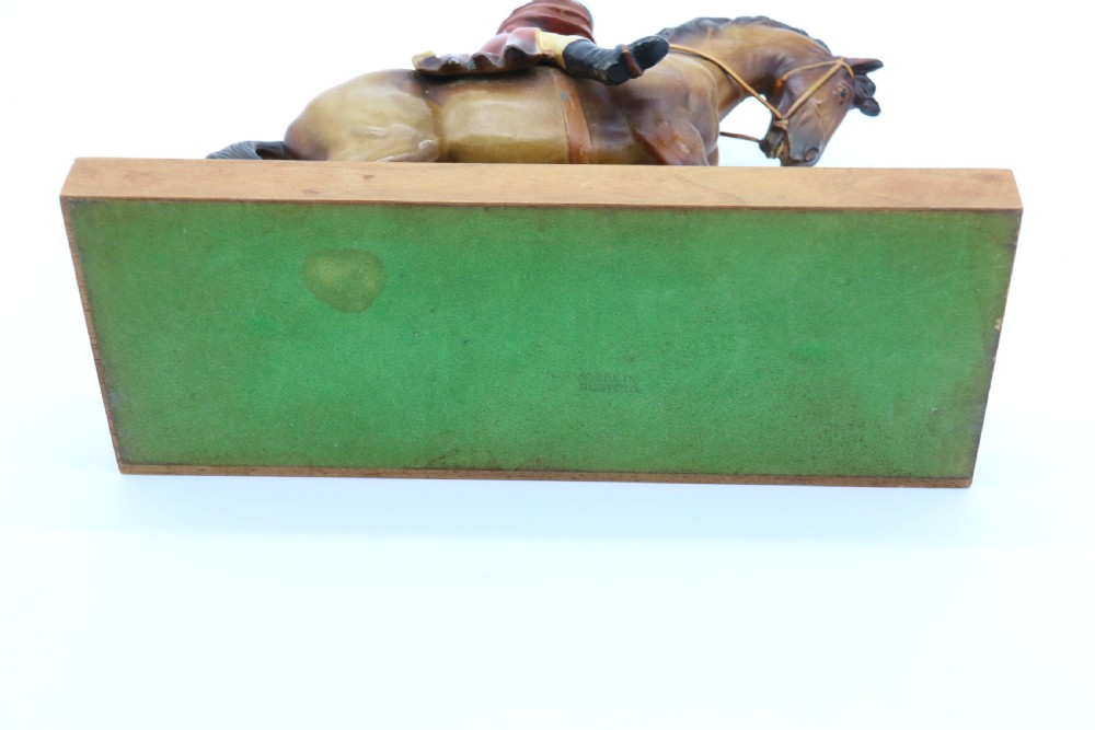 An Art Deco cold-painted metal figure of a masked highwayman on horseback mounted on a rectangular wooden plinth, featuring an integrated table lighter mechanism. View XIV