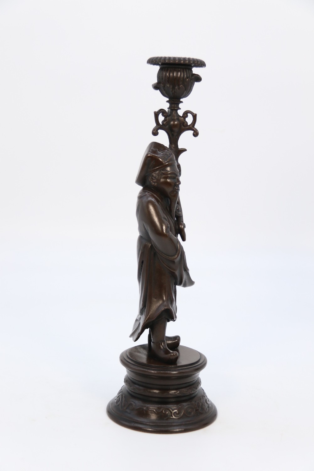 A pair of 19th-century French dark bronze candlesticks sculpted as standing Chinese figures holding flower-shaped candle nozzles on stepped round bases. View II