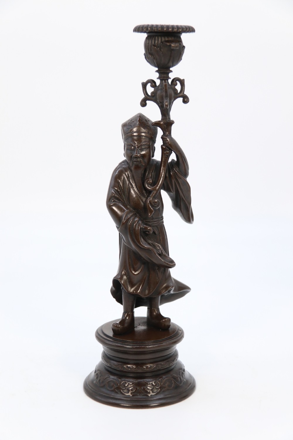 A pair of 19th-century French dark bronze candlesticks sculpted as standing Chinese figures holding flower-shaped candle nozzles on stepped round bases. View VII