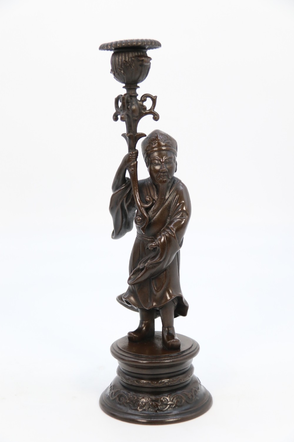 A pair of 19th-century French dark bronze candlesticks sculpted as standing Chinese figures holding flower-shaped candle nozzles on stepped round bases. View VIII
