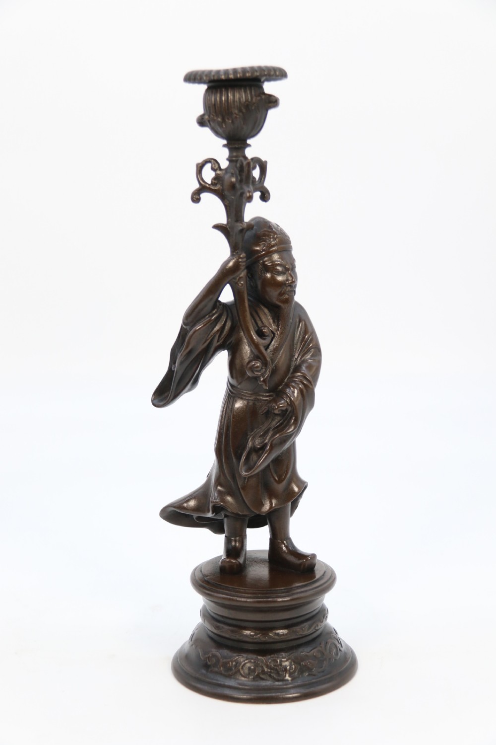 A pair of 19th-century French dark bronze candlesticks sculpted as standing Chinese figures holding flower-shaped candle nozzles on stepped round bases. View IX