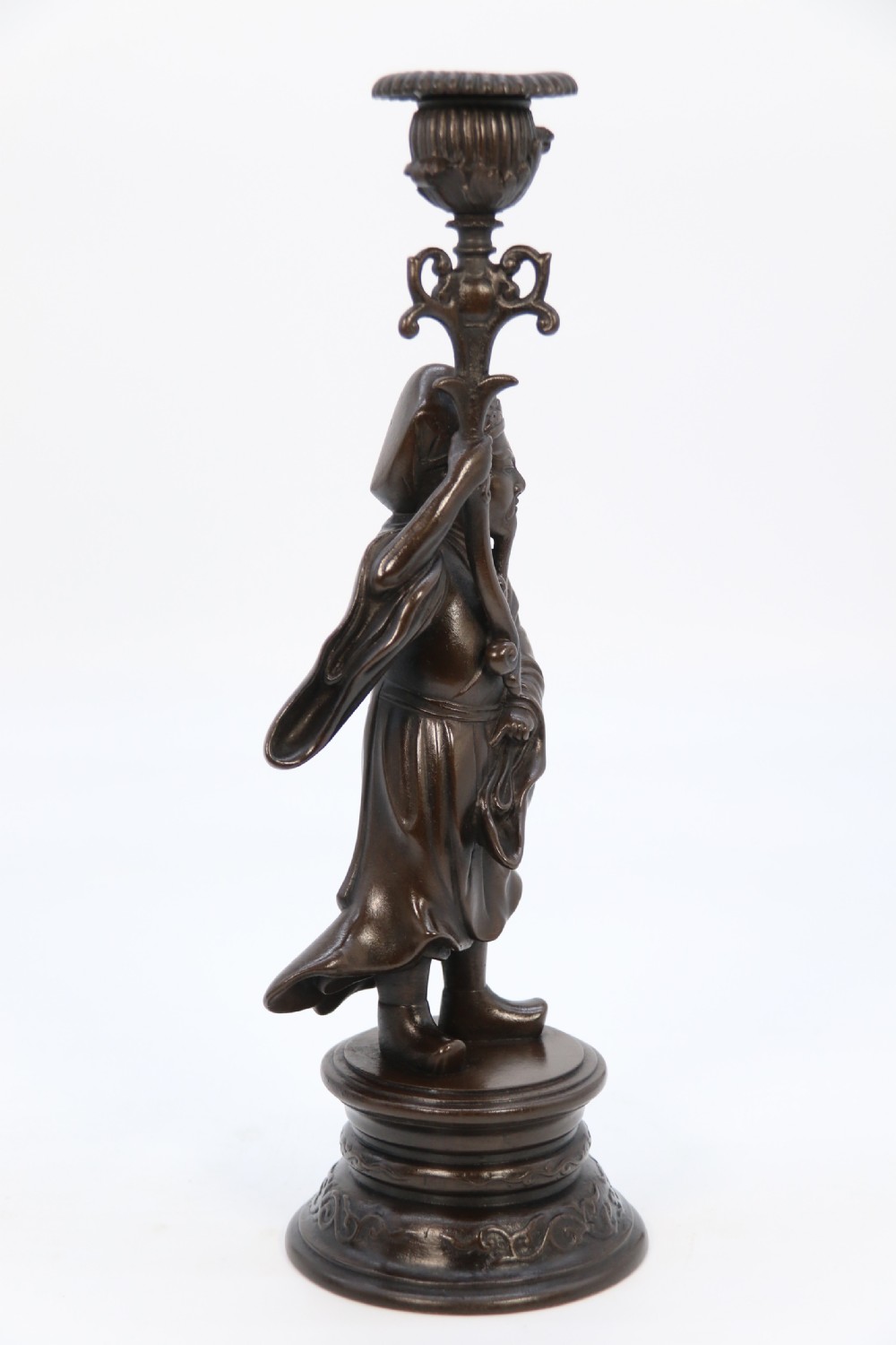 A pair of 19th-century French dark bronze candlesticks sculpted as standing Chinese figures holding flower-shaped candle nozzles on stepped round bases. View X