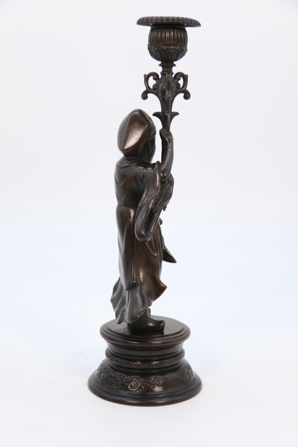 A pair of 19th-century French dark bronze candlesticks sculpted as standing Chinese figures holding flower-shaped candle nozzles on stepped round bases. View XI
