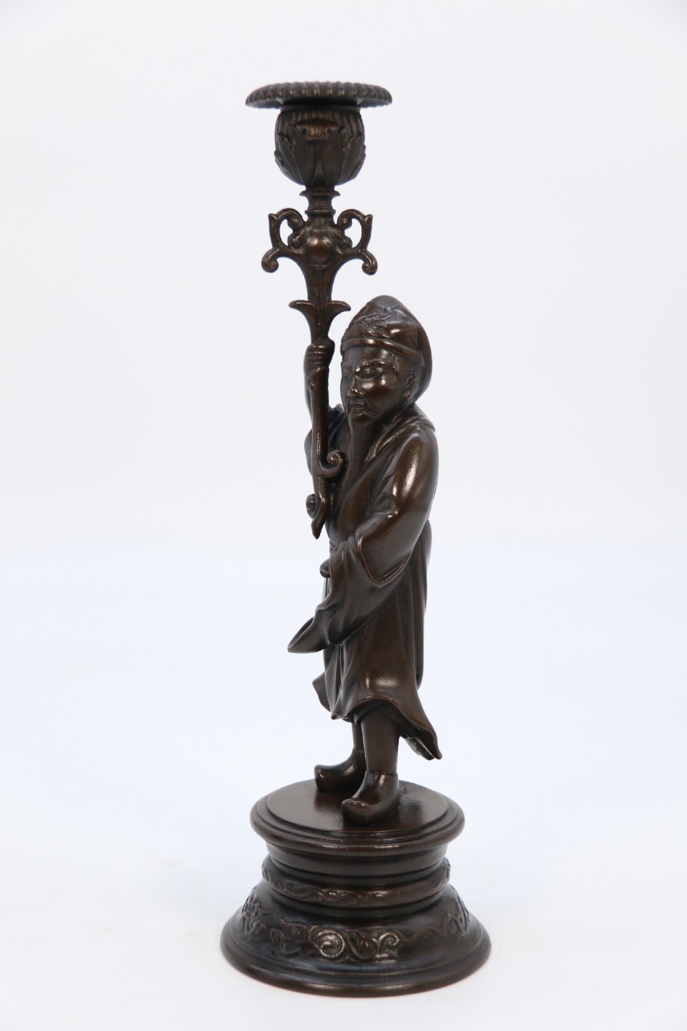 A pair of 19th-century French dark bronze candlesticks sculpted as standing Chinese figures holding flower-shaped candle nozzles on stepped round bases. View XIV