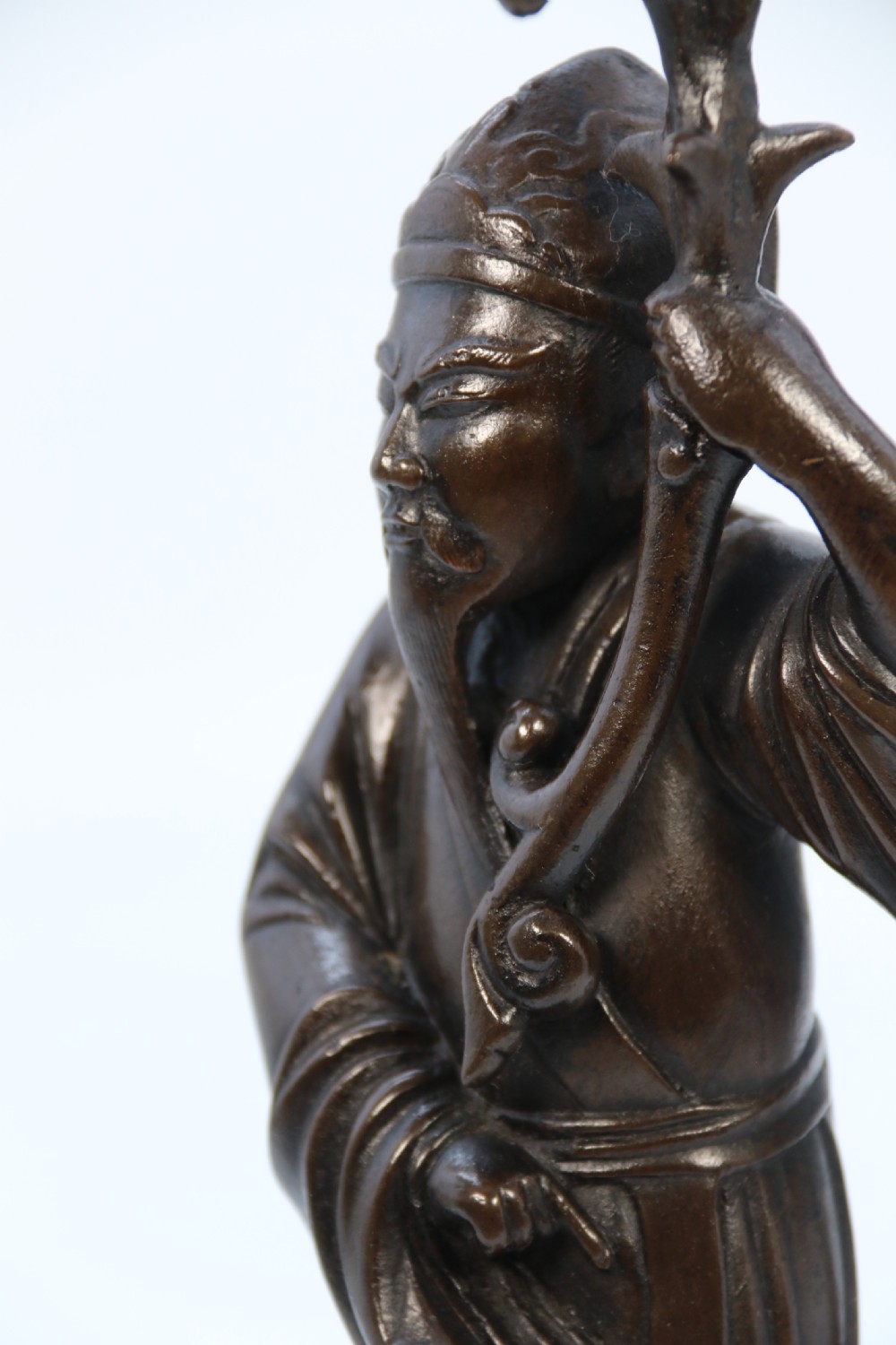 A pair of 19th-century French dark bronze candlesticks sculpted as standing Chinese figures holding flower-shaped candle nozzles on stepped round bases. View XXIV