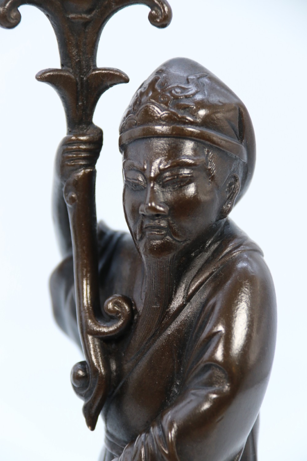 A pair of 19th-century French dark bronze candlesticks sculpted as standing Chinese figures holding flower-shaped candle nozzles on stepped round bases. View XXVII