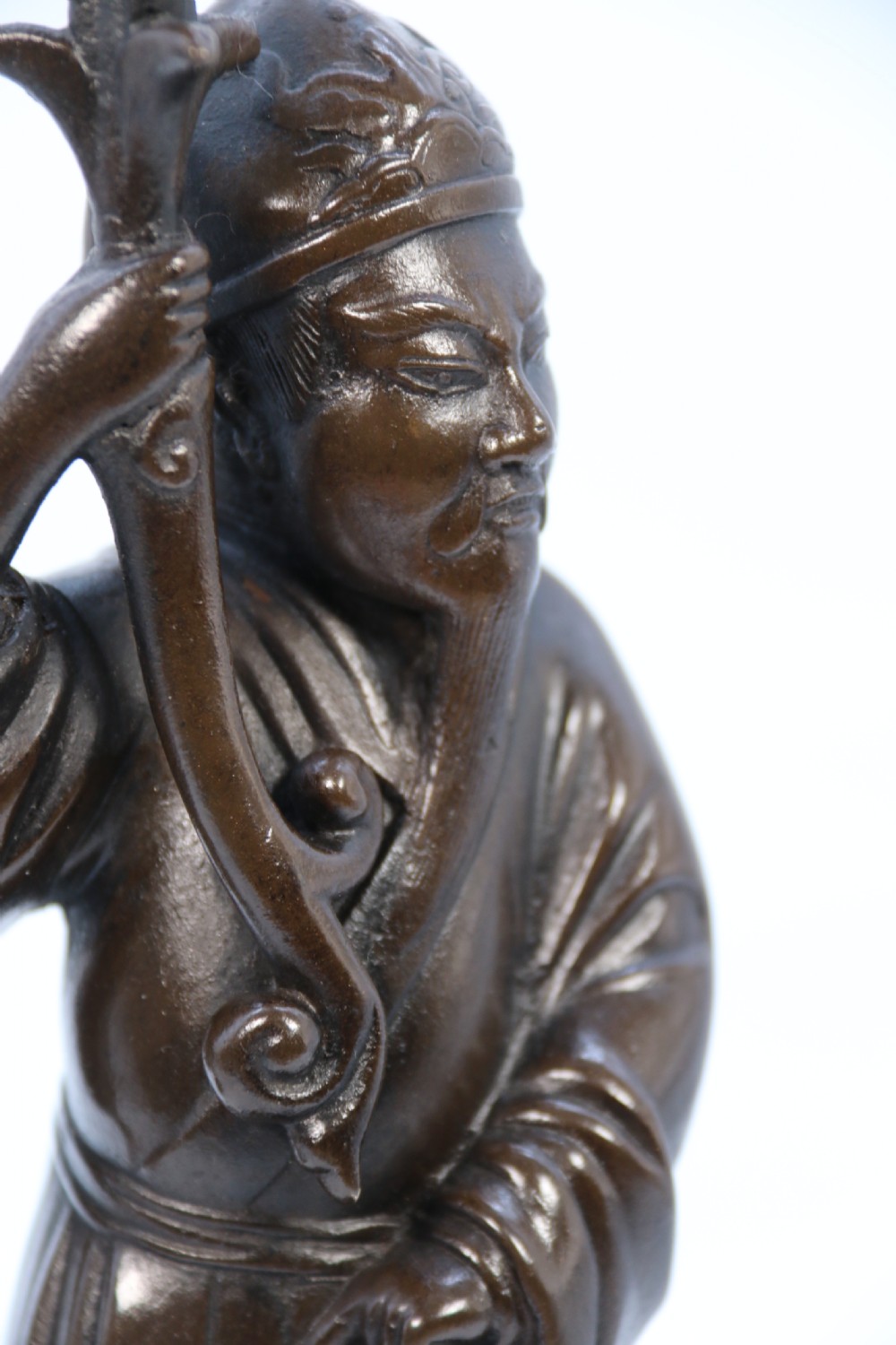 A pair of 19th-century French dark bronze candlesticks sculpted as standing Chinese figures holding flower-shaped candle nozzles on stepped round bases. View XXVIII