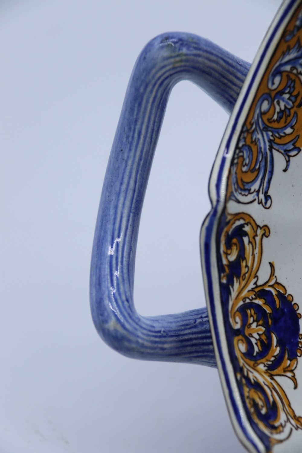 A hand-painted French Gien faience earthenware centrepiece dish with twin handles, decorated in cobalt blue and yellow mythological figures and acanthus scrollwork. View II