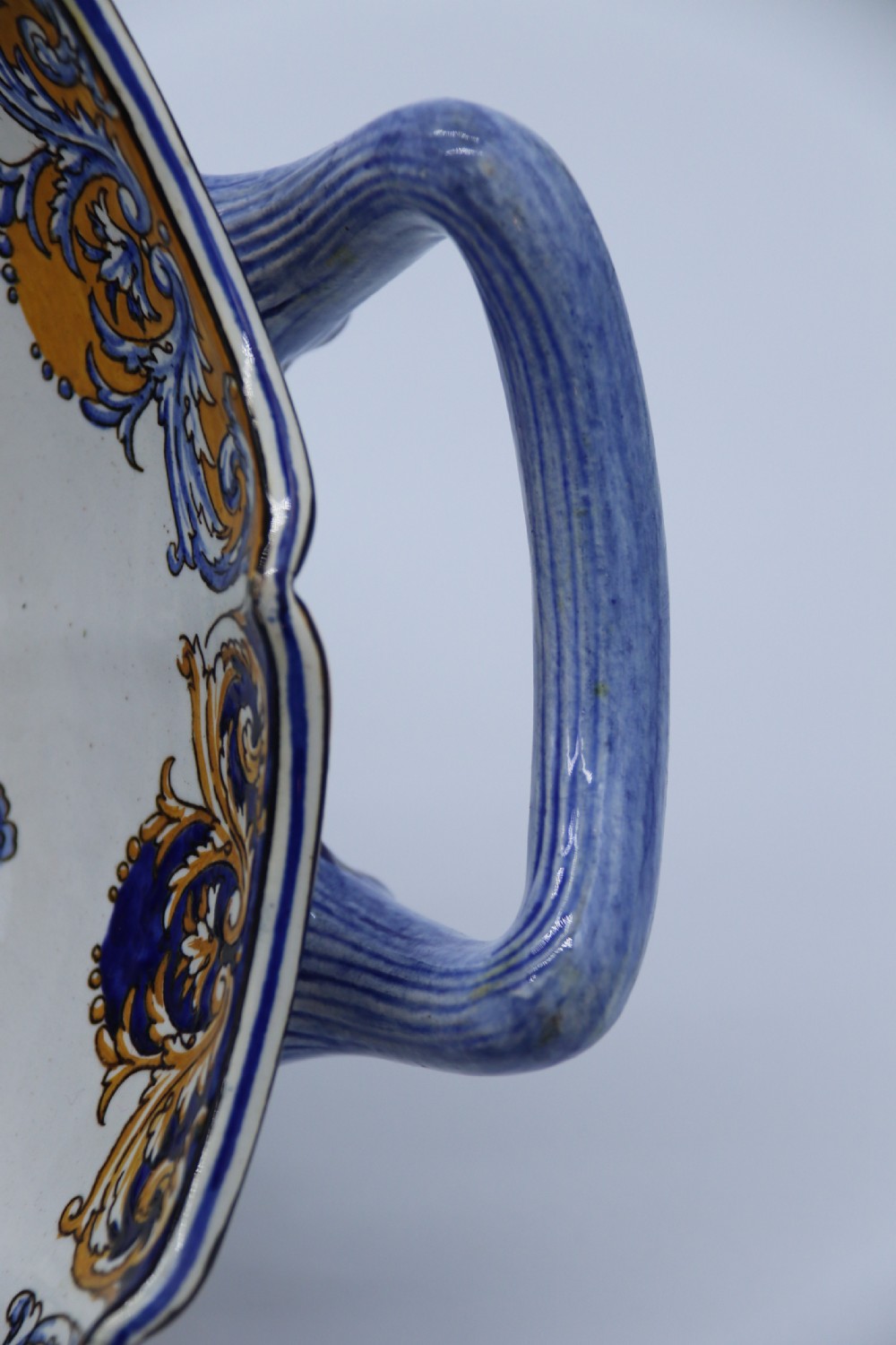 A hand-painted French Gien faience earthenware centrepiece dish with twin handles, decorated in cobalt blue and yellow mythological figures and acanthus scrollwork. View III