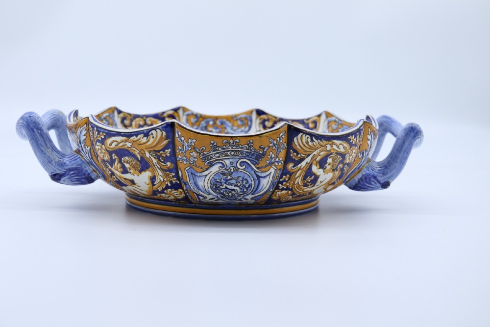 A hand-painted French Gien faience earthenware centrepiece dish with twin handles, decorated in cobalt blue and yellow mythological figures and acanthus scrollwork. View X