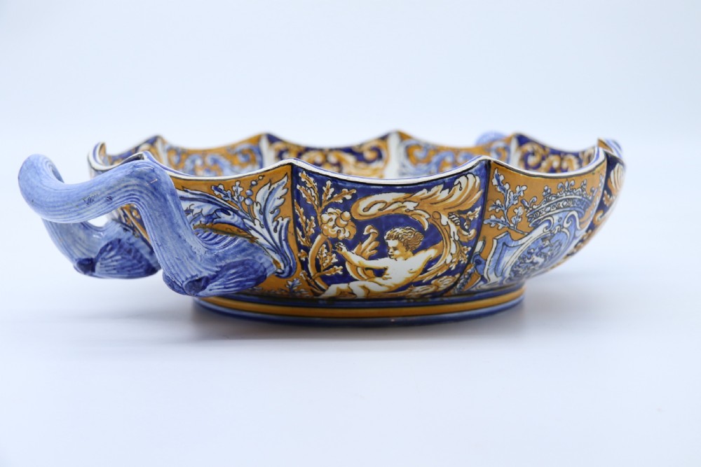 A hand-painted French Gien faience earthenware centrepiece dish with twin handles, decorated in cobalt blue and yellow mythological figures and acanthus scrollwork. View XI