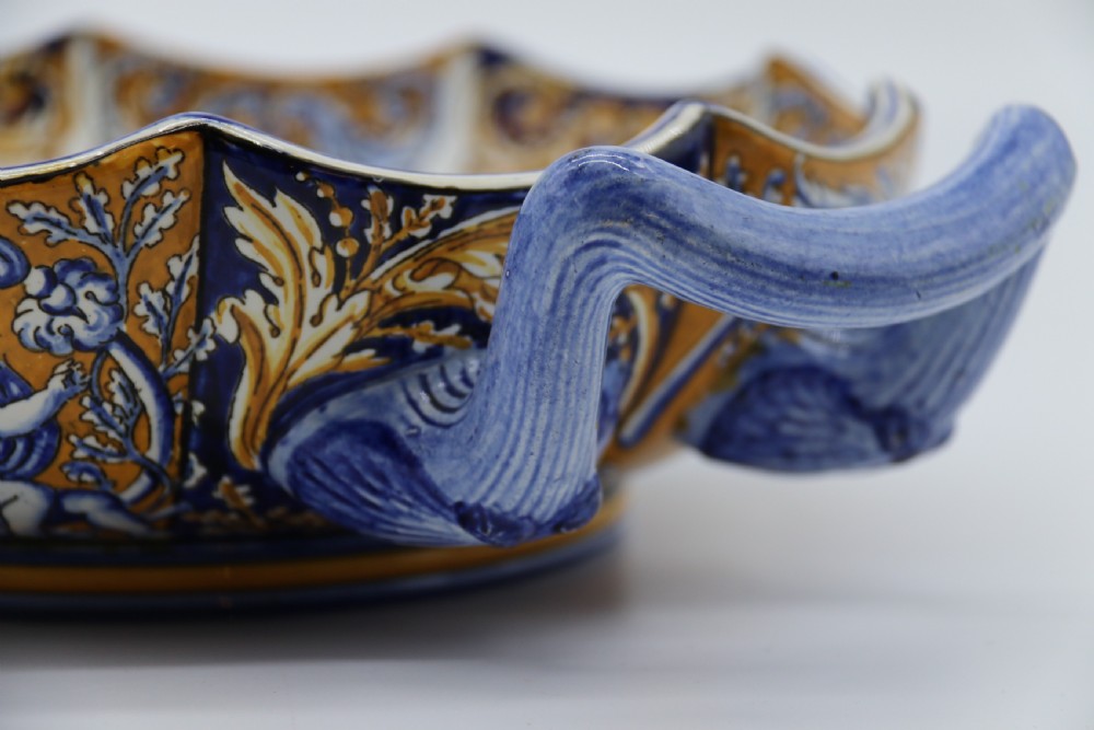 A hand-painted French Gien faience earthenware centrepiece dish with twin handles, decorated in cobalt blue and yellow mythological figures and acanthus scrollwork. View XIV
