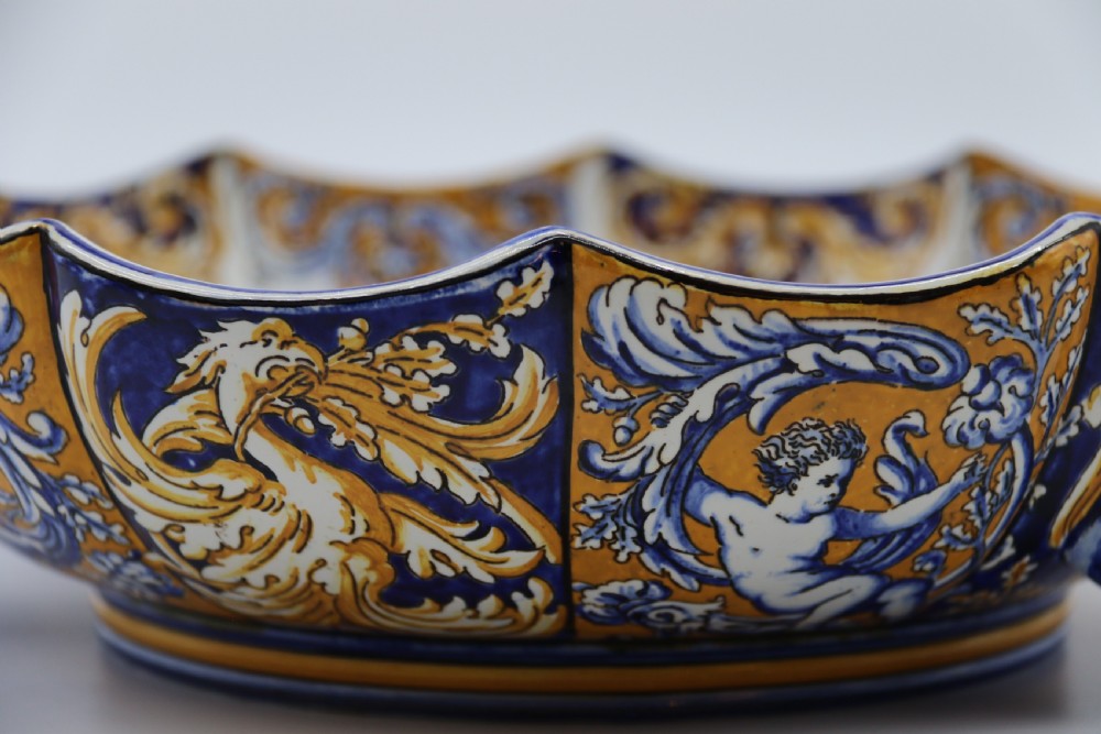 A hand-painted French Gien faience earthenware centrepiece dish with twin handles, decorated in cobalt blue and yellow mythological figures and acanthus scrollwork. View XV