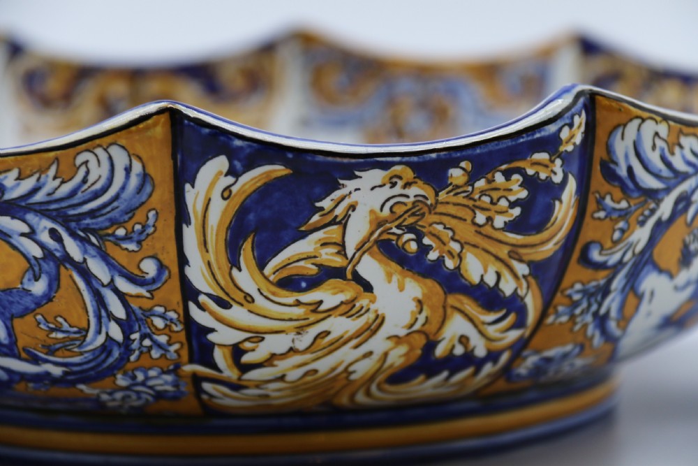 A hand-painted French Gien faience earthenware centrepiece dish with twin handles, decorated in cobalt blue and yellow mythological figures and acanthus scrollwork. View XVI