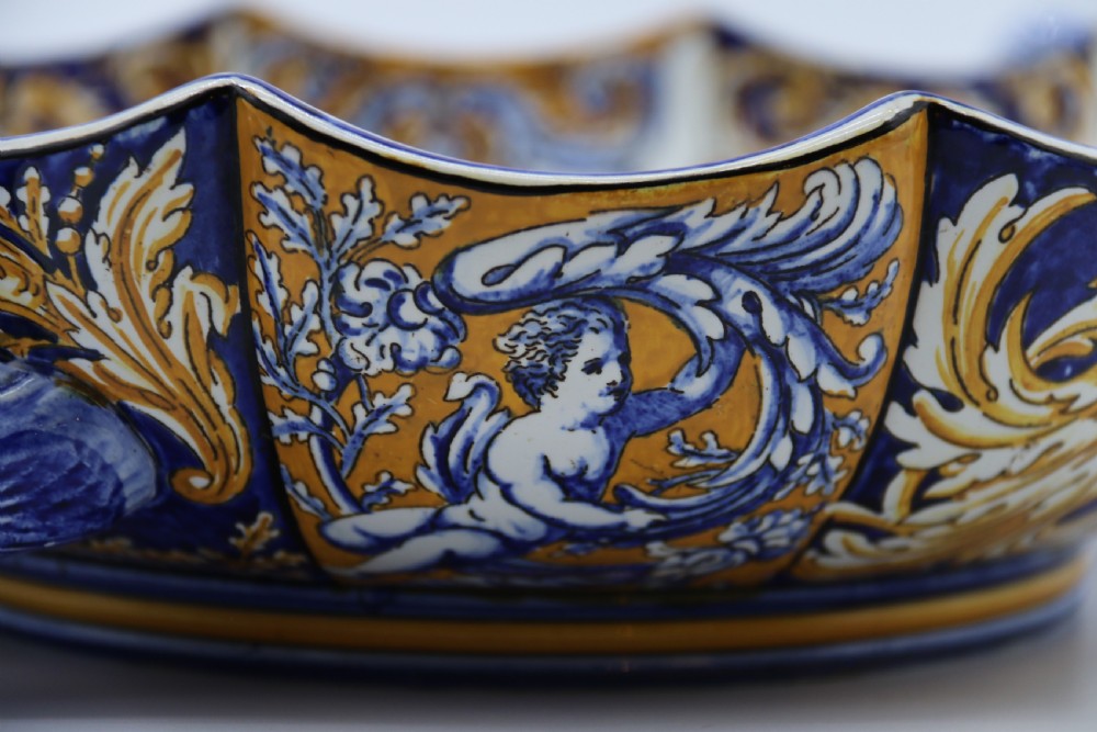 A hand-painted French Gien faience earthenware centrepiece dish with twin handles, decorated in cobalt blue and yellow mythological figures and acanthus scrollwork. View XVII
