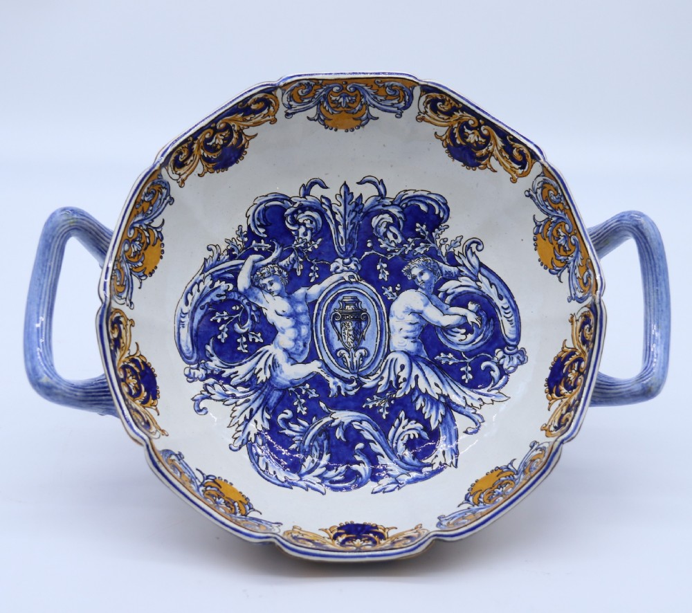 A hand-painted French Gien faience earthenware centrepiece dish with twin handles, decorated in cobalt blue and yellow mythological figures and acanthus scrollwork.