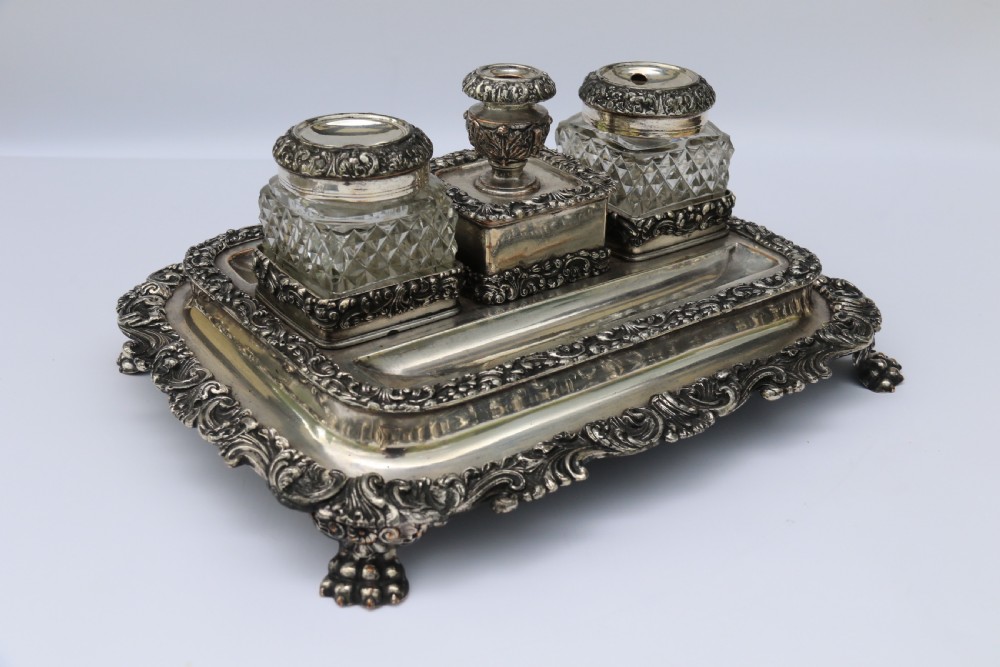An early nineteenth-century Sheffield plate desk inkstand featuring two cut-glass inkwells and decorative scroll borders raised on paw feet. View III