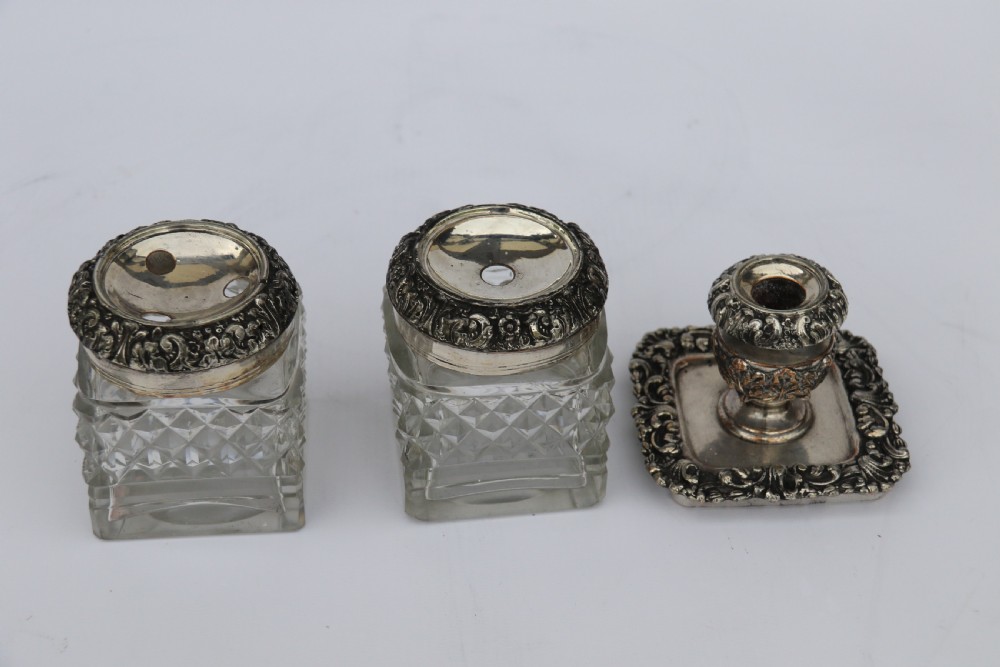 An early nineteenth-century Sheffield plate desk inkstand featuring two cut-glass inkwells and decorative scroll borders raised on paw feet. View XIV