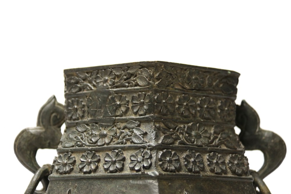 A hexagonal dark bronze Chinese vessel featuring cast relief decoration of fish, pagodas, and floral neck bands with twin side handles. View VII