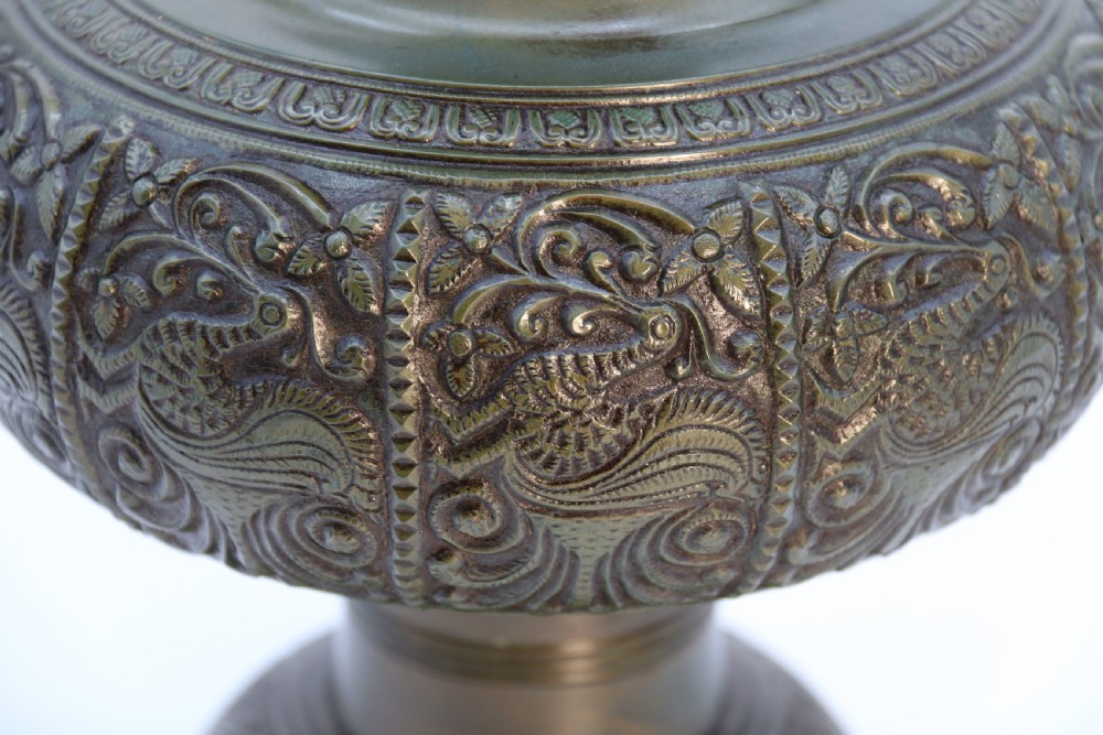 An antique nineteenth-century patinated bronze vase featuring hand-chased floral and foliate motifs, a bulbous center, flared neck, and circular base. View III