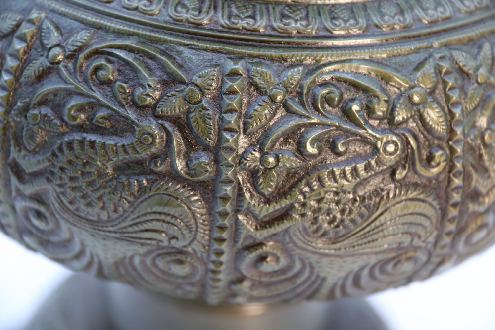 An antique nineteenth-century patinated bronze vase featuring hand-chased floral and foliate motifs, a bulbous center, flared neck, and circular base. View IX