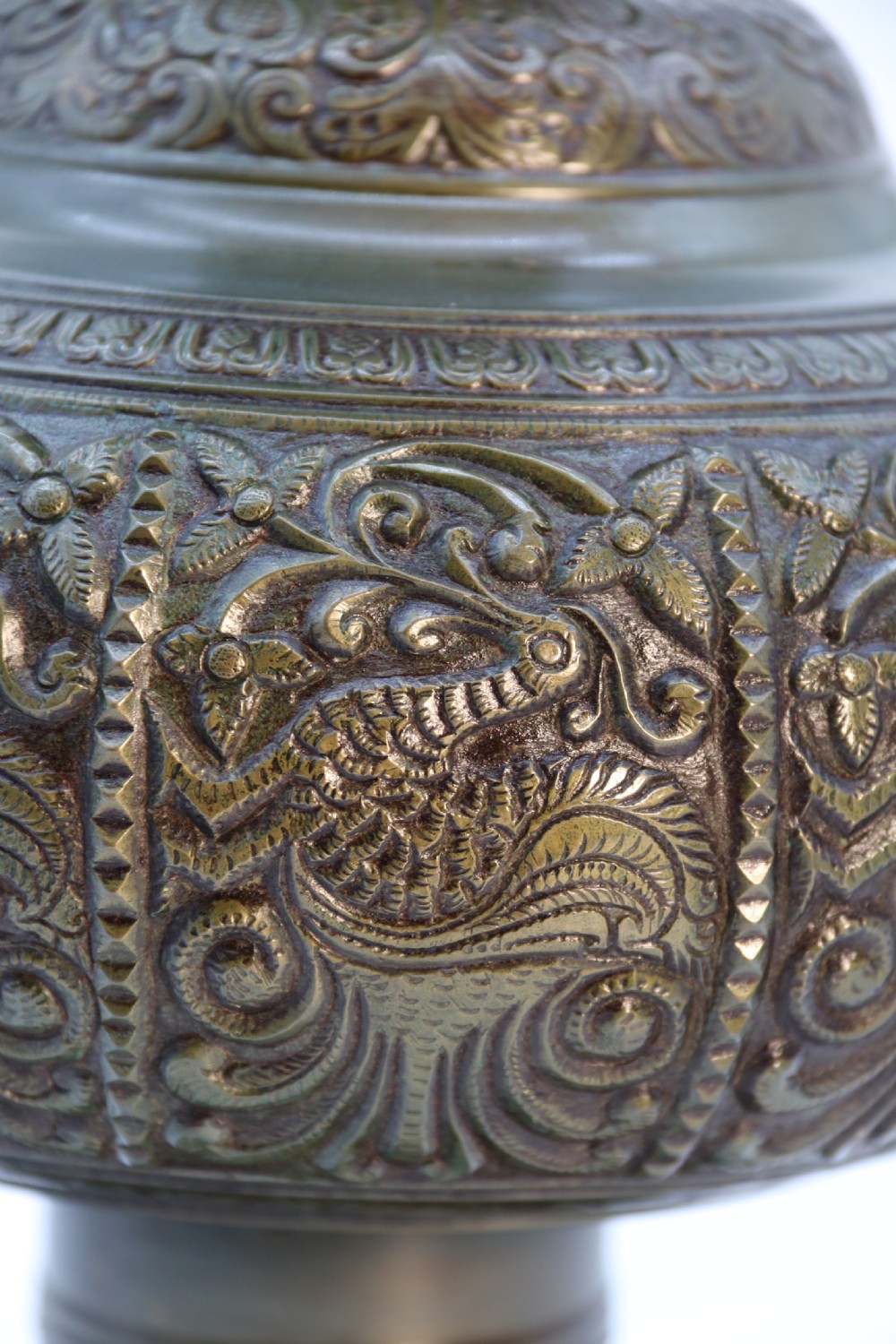 An antique nineteenth-century patinated bronze vase featuring hand-chased floral and foliate motifs, a bulbous center, flared neck, and circular base. View X