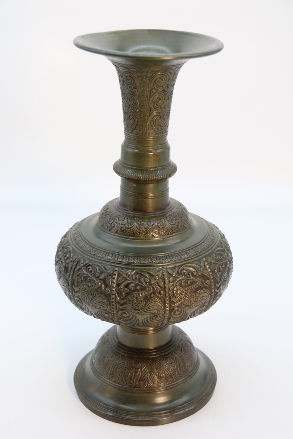 An antique nineteenth-century patinated bronze vase featuring hand-chased floral and foliate motifs, a bulbous center, flared neck, and circular base. View XVI
