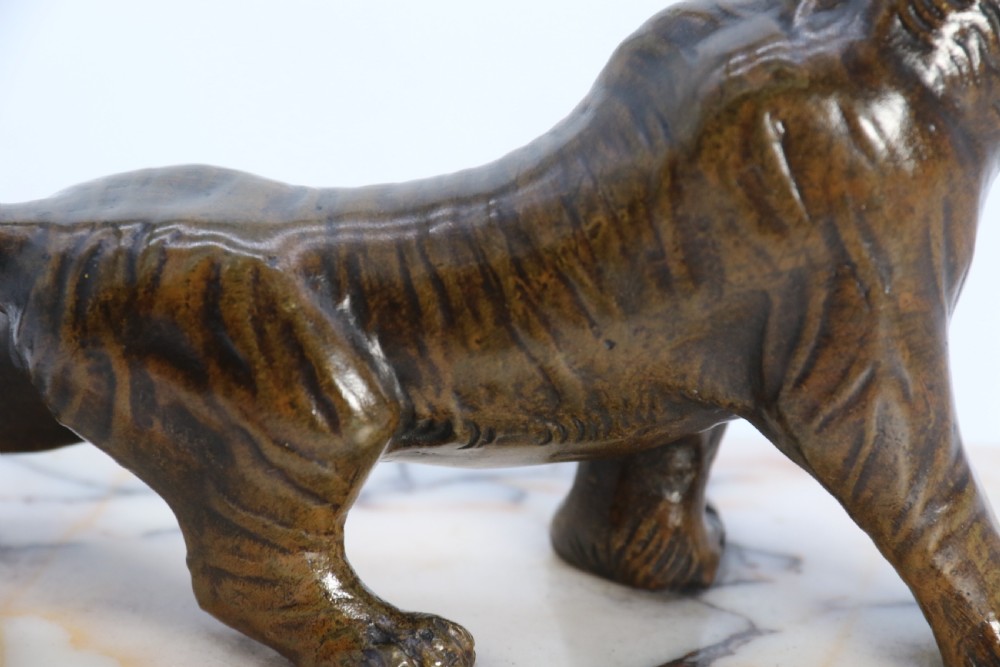 A dark bronze tiger sculpture posed in a roaring stance, mounted on a rectangular veined marble base. View IV
