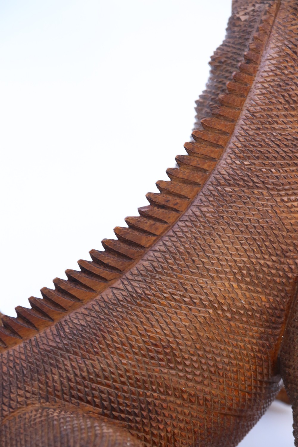 A hand-carved hardwood sculpture of an iguana featuring detailed scale patterns, a serrated dorsal crest, and a prominent dewlap in a warm brown finish. View XII