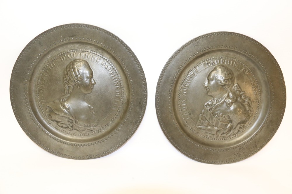 A pair of round silver grey pewter plates featuring raised profile relief portraits of Marie Antoinette and Louis XVI with beaded outer borders. View II