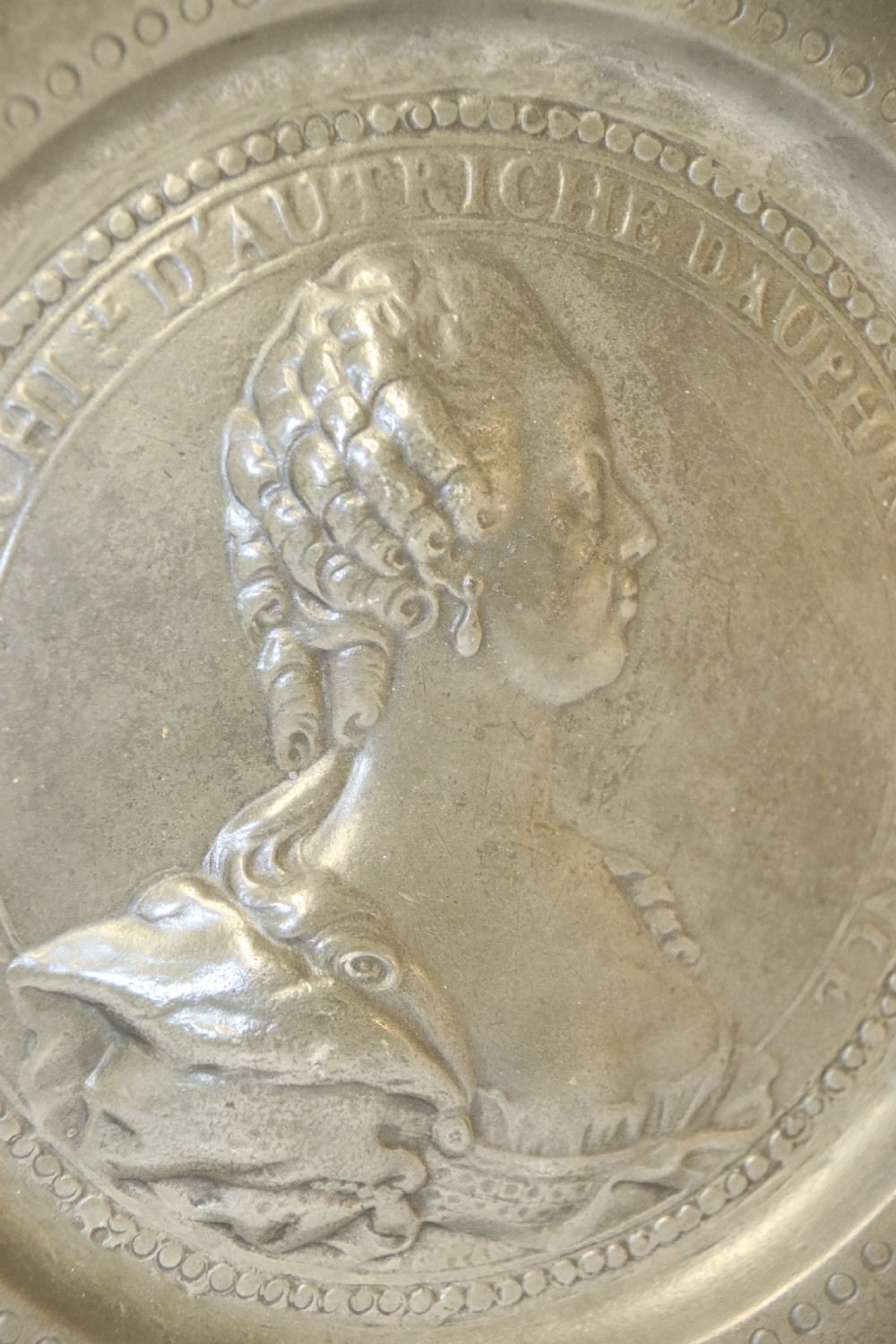 A pair of round silver grey pewter plates featuring raised profile relief portraits of Marie Antoinette and Louis XVI with beaded outer borders. View V