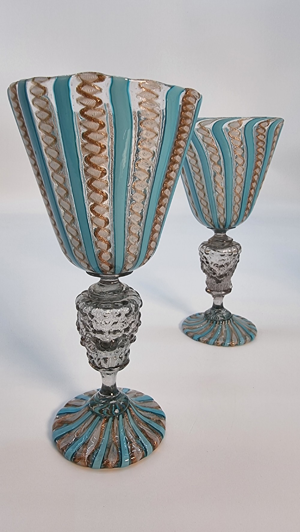 An antique Venetian glass claret set featuring a striped turquoise blue and white latticinio ewer with handle, matching saucer, and two stemware goblets. View XIX