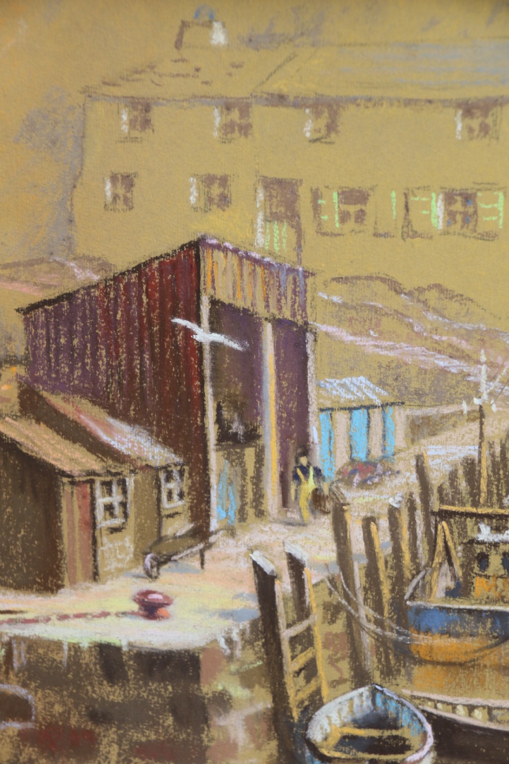 A framed pastel drawing depicting Polperro Harbour with fishing boats and stone cottages, set within an ornate swept frame. View IV