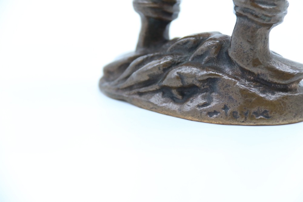 A dark brown patinated bronze statuette depicting a figure in historic costume playing a pipe while standing on a textured base. View VIII