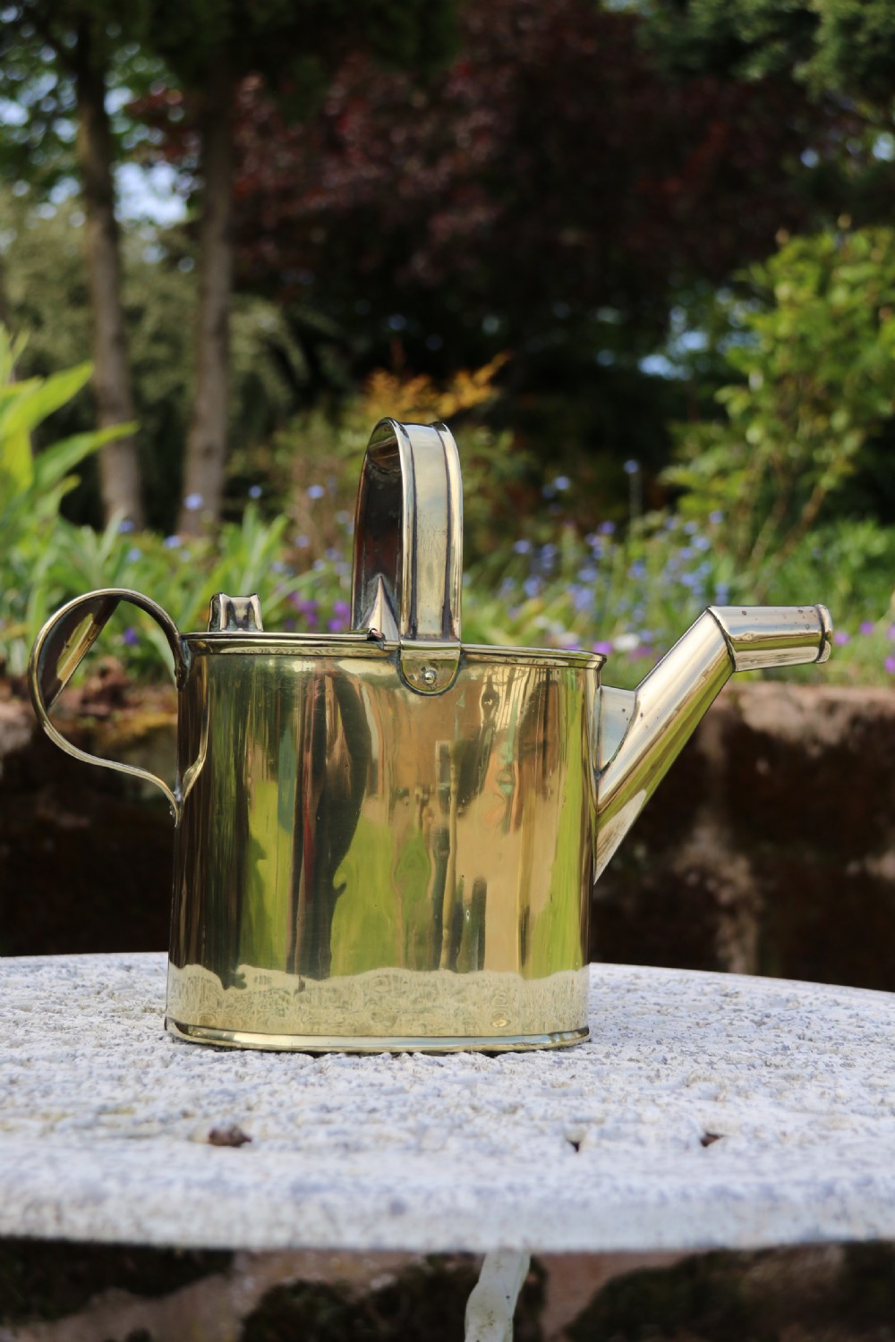 A pair of polished 19th-century brass watering cans in differing sizes featuring reeded cylindrical bodies, arched top handles, and angled spouts. View XVI