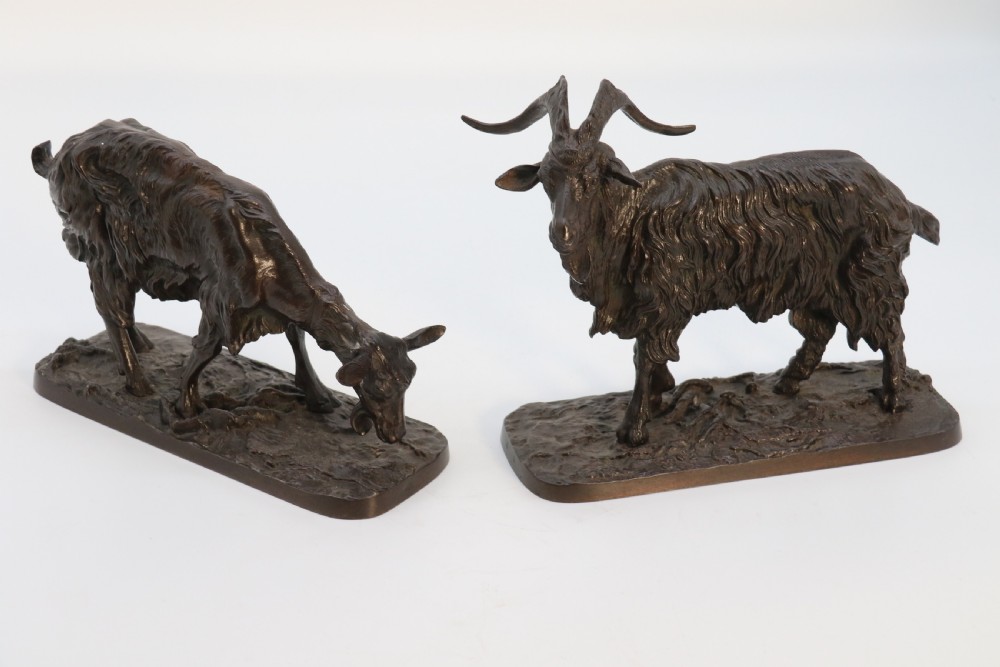 A pair of 19th-century French dark brown patinated bronze sculptures depicting a standing horned goat and a grazing goat on naturalistic bases. View VI