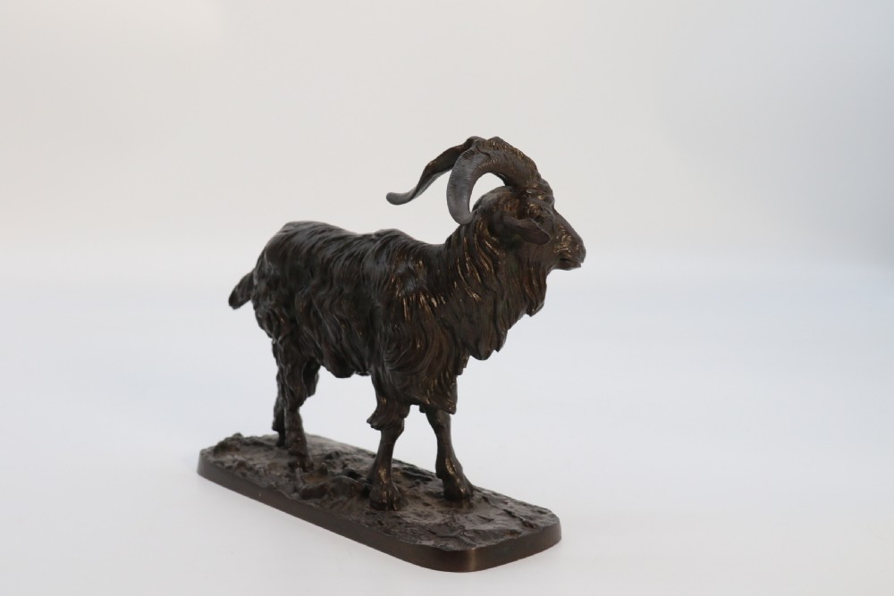 A pair of 19th-century French dark brown patinated bronze sculptures depicting a standing horned goat and a grazing goat on naturalistic bases. View X