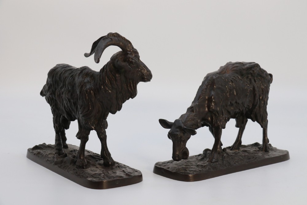 A pair of 19th-century French dark brown patinated bronze sculptures depicting a standing horned goat and a grazing goat on naturalistic bases. View XXIV