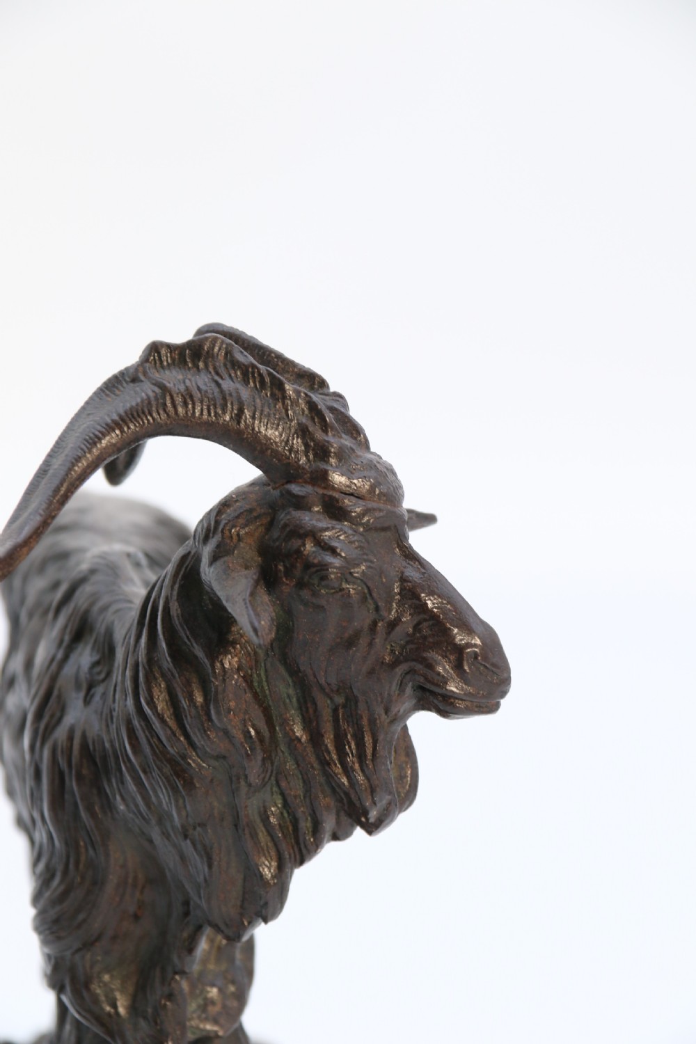 A pair of 19th-century French dark brown patinated bronze sculptures depicting a standing horned goat and a grazing goat on naturalistic bases. View XXVII