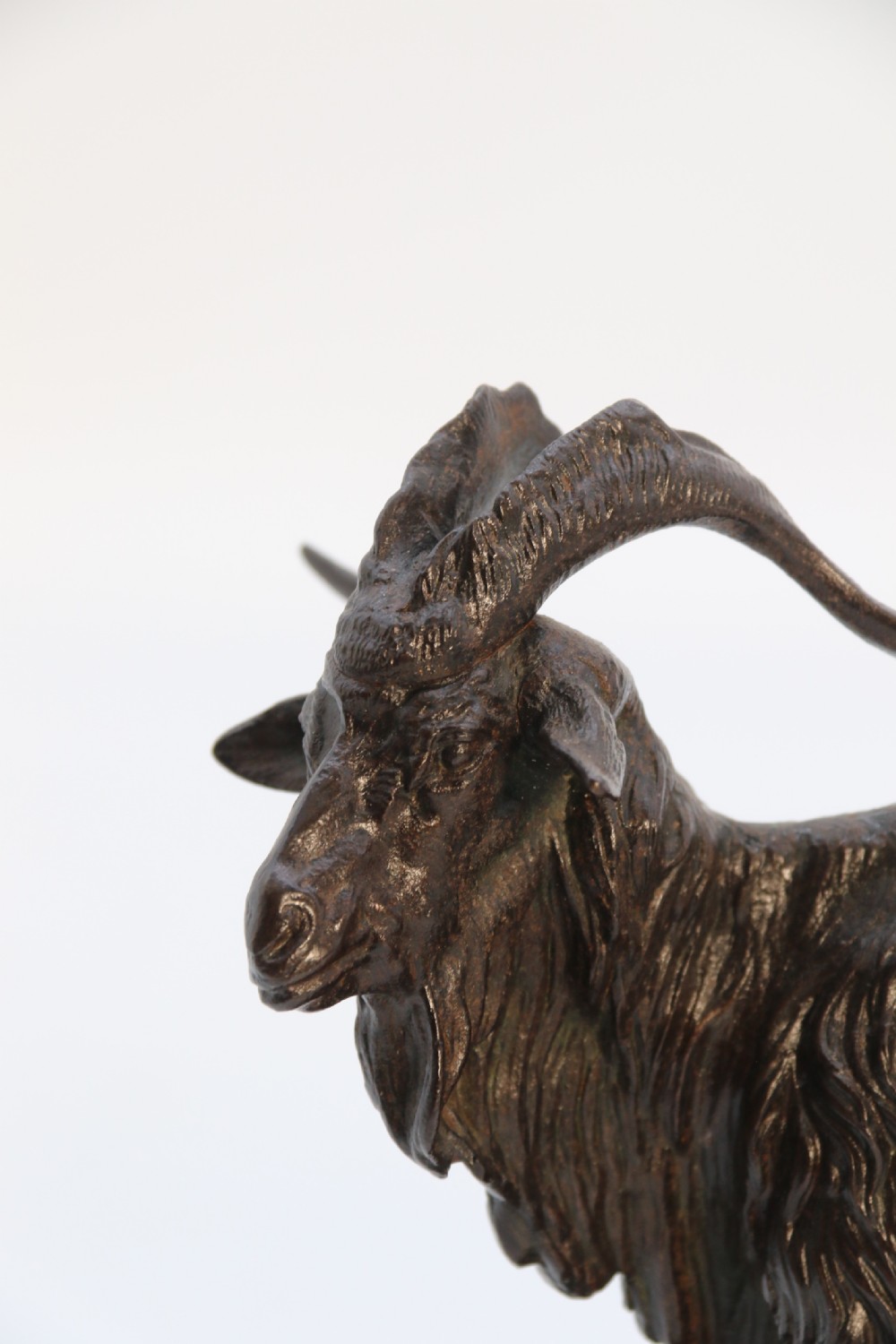 A pair of 19th-century French dark brown patinated bronze sculptures depicting a standing horned goat and a grazing goat on naturalistic bases. View XXVIII