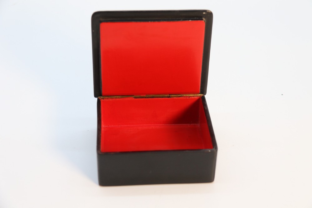A square black lacquered box featuring a hand-painted portrait of a young woman with brown hair and a red ribbon. View VII