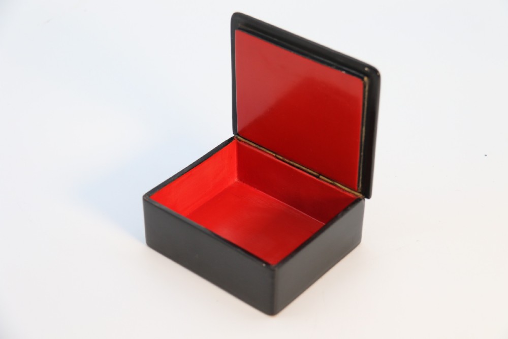 A square black lacquered box featuring a hand-painted portrait of a young woman with brown hair and a red ribbon. View VIII