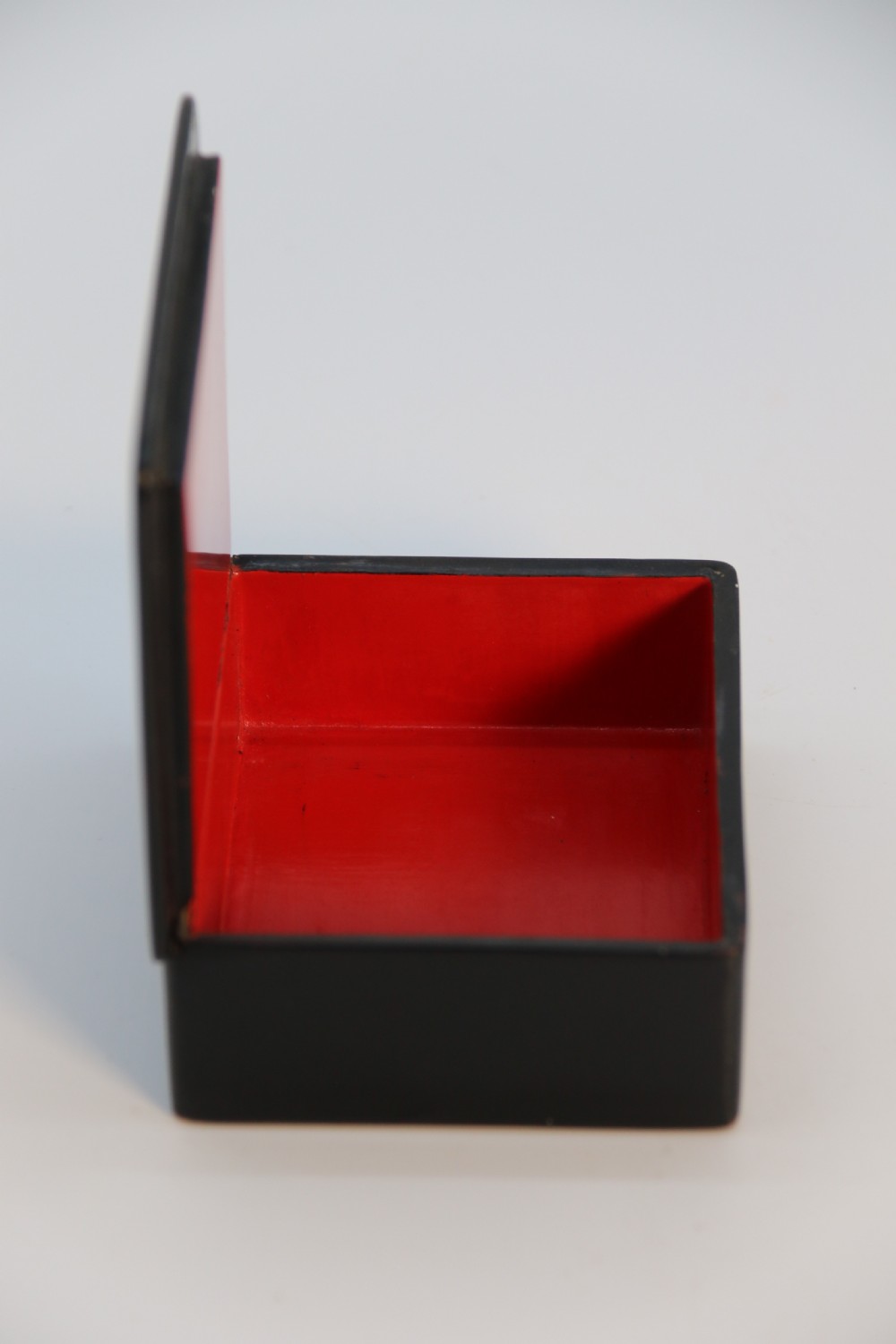 A square black lacquered box featuring a hand-painted portrait of a young woman with brown hair and a red ribbon. View XI
