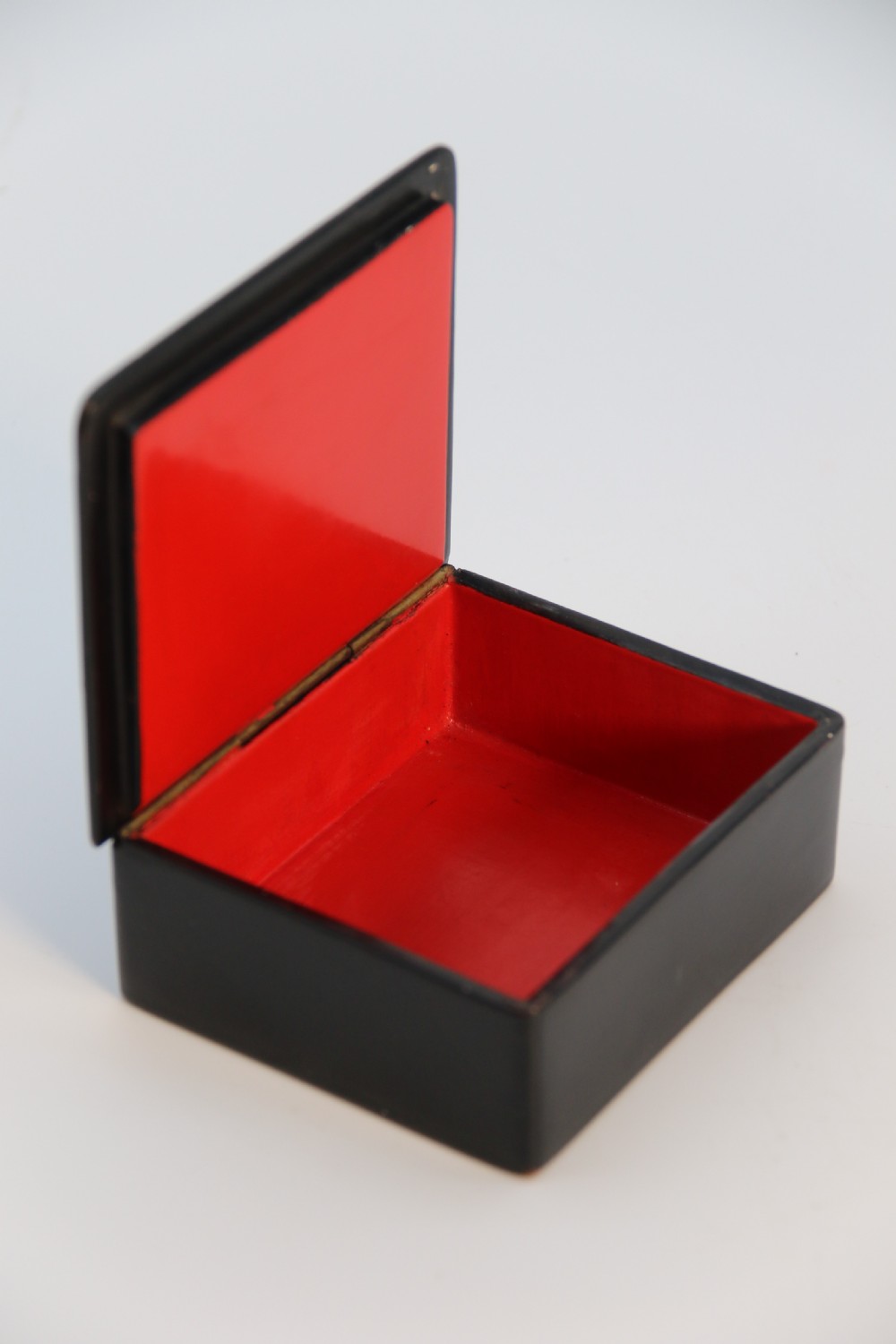 A square black lacquered box featuring a hand-painted portrait of a young woman with brown hair and a red ribbon. View XIII