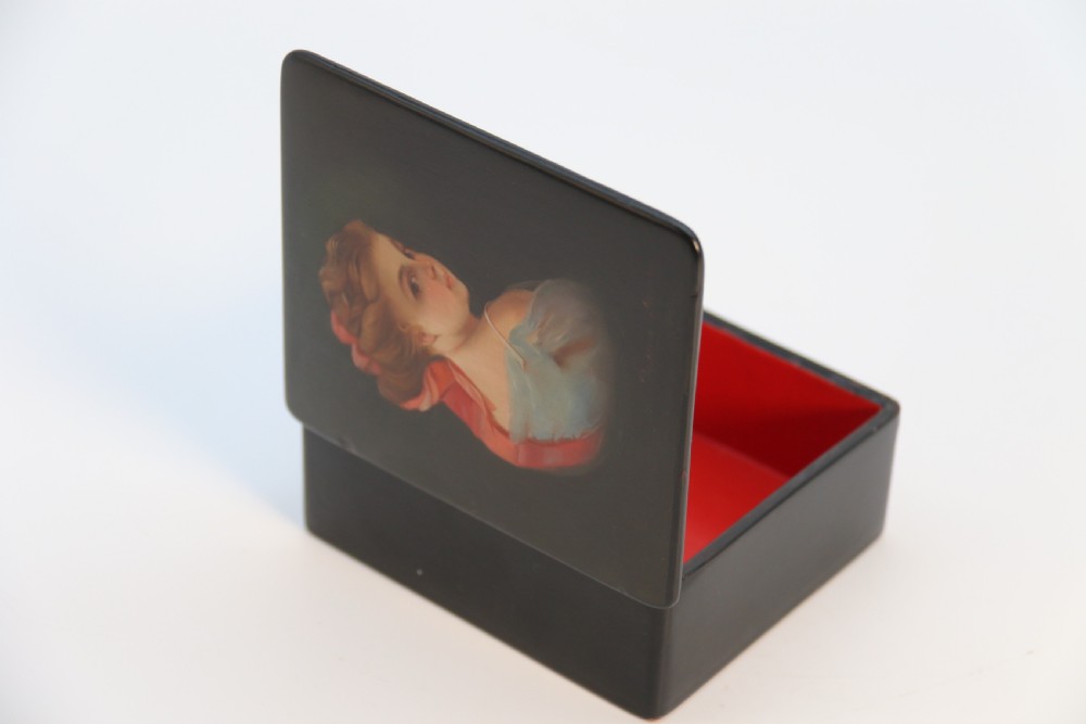 A square black lacquered box featuring a hand-painted portrait of a young woman with brown hair and a red ribbon. View XV